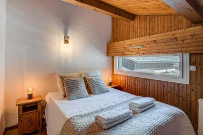 a bedroom with a bed with pillows and a window at Apartment Mika , Alpes Travel, Slope side location, Central Chamonix, Sleeps 4 6 in Chamonix-Mont-Blanc
