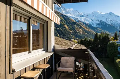 a balcony with chairs and a view of mountains at Apartment Mika , Alpes Travel, Slope side location, Central Chamonix, Sleeps 4 6 in Chamonix-Mont-Blanc