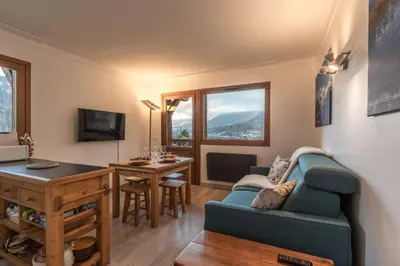 a living room with a blue couch and a table at Grand Balcon 7 in Les Houches