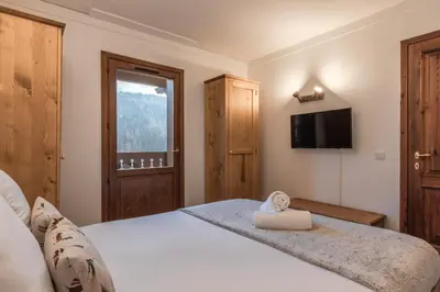 a bedroom with a bed with a tv on the wall at Grand Balcon 7 in Les Houches