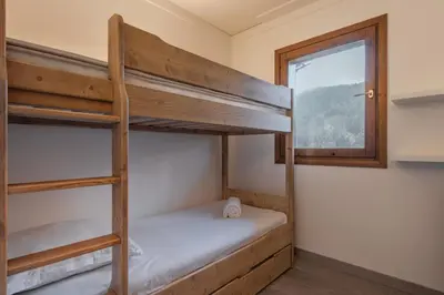 a bunk bed in a room with a window at Grand Balcon 7 in Les Houches