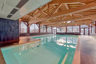 a swimming pool in a house with wooden ceilings at Appartement LE BUET skis aux pieds, piscine & Spa in Vallorcine