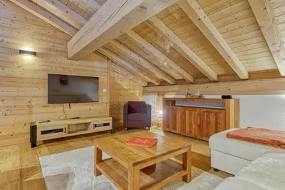 a living room with a couch and a tv at Appartement LE BUET skis aux pieds, piscine & Spa in Vallorcine