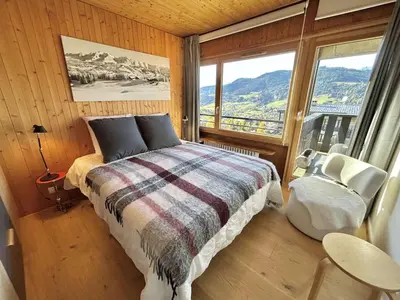 a bedroom with a bed and a large window at Appartement Megève 3 pièces, 4-6 personnes, parking - FR-1-597-195 in Megève