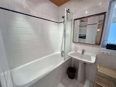 a white bathroom with a sink and a tub and a mirror at Appartement Megève 3 pièces, 4-6 personnes, parking - FR-1-597-195 in Megève