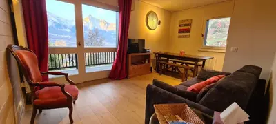 a living room with a couch and a table and a window at Les Cimes de Saint-Gervais apartment in Saint-Gervais-les-Bains