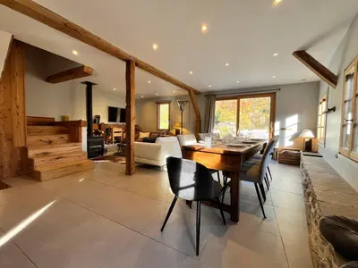 a living room with a wooden table and chairs at Chalet rénové à Samoëns, proche centre, skis-bus - FR-1-624-186 in Samoëns