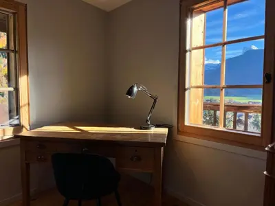 a desk with a lamp and a chair next to a window at Chalet rénové à Samoëns, proche centre, skis-bus - FR-1-624-186 in Samoëns