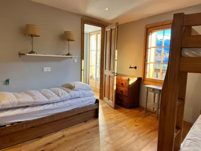 a bedroom with a bed and a wooden floor at Chalet rénové à Samoëns, proche centre, skis-bus - FR-1-624-186 in Samoëns
