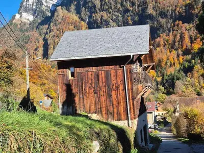 an old wooden barn on a hill with a mountain at Chalet rénové à Samoëns, proche centre, skis-bus - FR-1-624-186 in Samoëns