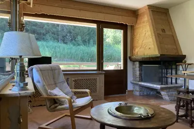 a living room with a chair and a fireplace at Stay Mountain with View and Optimal Comfort in Megève