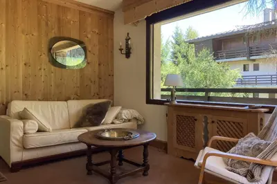a living room with a couch and a table and a window at Stay Mountain with View and Optimal Comfort in Megève