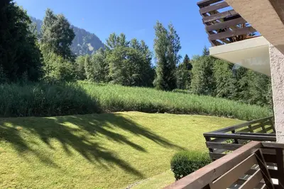 a view from the balcony of a house with a grassy field at Stay Mountain with View and Optimal Comfort in Megève