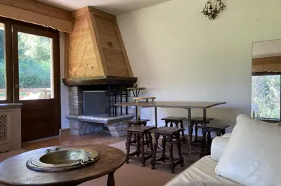 a living room with a table and a fireplace at Stay Mountain with View and Optimal Comfort in Megève
