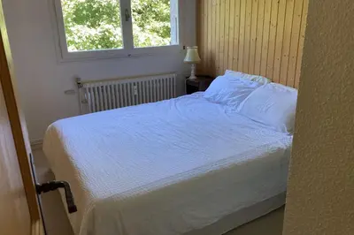 a bedroom with a bed with white sheets and a window at Stay Mountain with View and Optimal Comfort in Megève