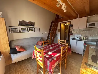 a kitchen and a living room with a table and a couch at Charmant T2 Mezzanine au centre - Animaux acceptés - FR-1-624-187 in Samoëns