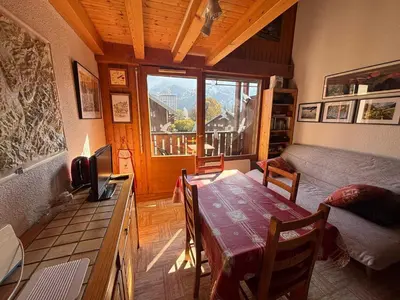 a living room with a table and a bed and a window at Charmant T2 Mezzanine au centre - Animaux acceptés - FR-1-624-187 in Samoëns