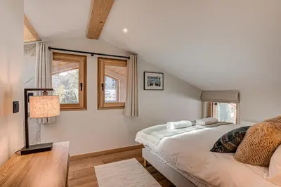 a bedroom with a bed and two windows at Chalet Diard, Detached Chalet, Alpes Travel, Sleeps 6 to 8 in Chamonix-Mont-Blanc