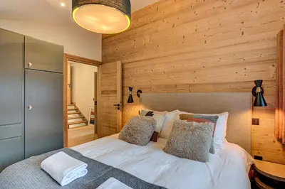 a bedroom with a bed with a wooden wall at Chalet Diard, Detached Chalet, Alpes Travel, Sleeps 6 to 8 in Chamonix-Mont-Blanc