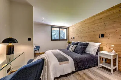 a bedroom with a bed and a wooden wall at Chalet du Cristal Blanc in Chamonix-Mont-Blanc