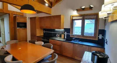 a kitchen with a wooden table and a dining room at Appartement style chalet, proche remontées avec garage in Les Houches