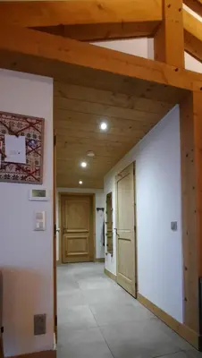 an empty hallway with wooden ceilings and a door at Appartement style chalet, proche remontées avec garage in Les Houches