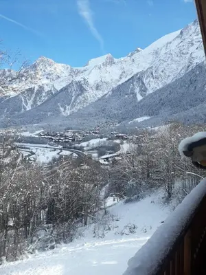 a view of a snowy mountain range from a balcony at Appartement style chalet, proche remontées avec garage in Les Houches