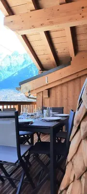 a dining room with a table with wine glasses on it at Appartement style chalet, proche remontées avec garage in Les Houches