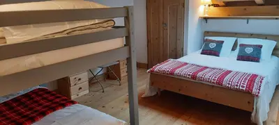 two bunk beds in a room with a bed at Appartement style chalet, proche remontées avec garage in Les Houches