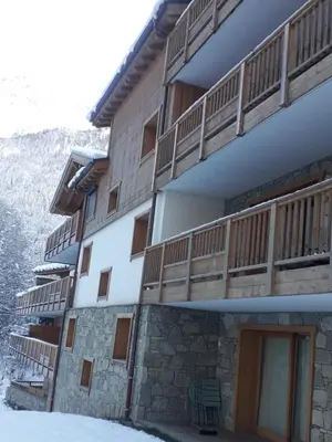 a building with wooden balconies on the side of it at Appartement style chalet, proche remontées avec garage in Les Houches