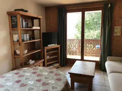 a living room with a bed and a large window at Appartement 3 pièces - 6 pers. - Pied de piste avec garage - FR-1-836-14 in Arâches-la-Frasse