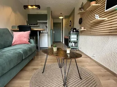 a living room with a green couch and a table at Studio cosy rénové avec balcon sud - 2 pers. - FR-1-836-15 in Arâches-la-Frasse