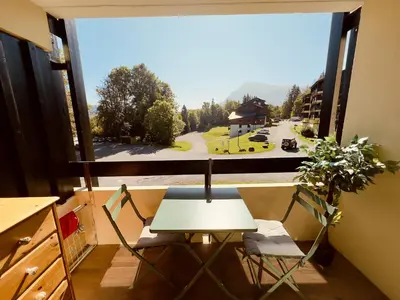 a table and chairs in a room with a large window at Studio cosy rénové avec balcon sud - 2 pers. - FR-1-836-15 in Arâches-la-Frasse