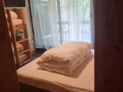 a bed with a white comforter and a window at Charmant T2 à Arâches-la-Frasse, pour 4 personnes - FR-1-836-19 in Arâches-la-Frasse