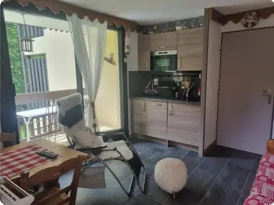 a living room with a chair and a table and a kitchen at Charmant T2 à Arâches-la-Frasse, pour 4 personnes - FR-1-836-19 in Arâches-la-Frasse