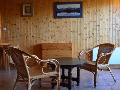 a table and chairs in a room with a wooden wall at Charmant 2 pièces avec WIFI et 4 couchages à Le Pernant - FR-1-836-16 in Arâches-la-Frasse