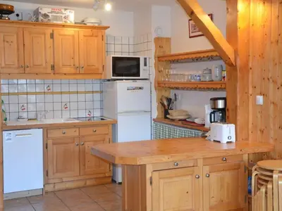 a kitchen with wooden cabinets and white appliances at Charmant 2 pièces avec WIFI et 4 couchages à Le Pernant - FR-1-836-16 in Arâches-la-Frasse