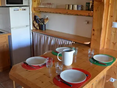 a kitchen with a wooden table with plates on it at Charmant 2 pièces avec WIFI et 4 couchages à Le Pernant - FR-1-836-16 in Arâches-la-Frasse
