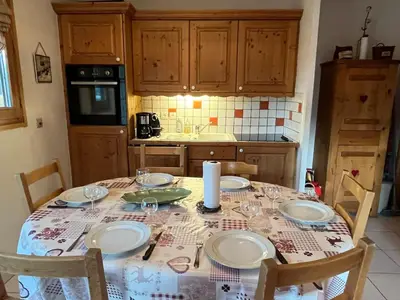 a kitchen with a table with plates and glasses on it at Appart spacieux 6 pers Samoëns avec animaux admis - FR-1-629-151 in Samoëns