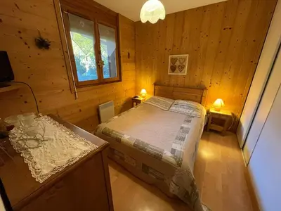 a bedroom with a bed in a wooden cabin at Appart spacieux 6 pers Samoëns avec animaux admis - FR-1-629-151 in Samoëns