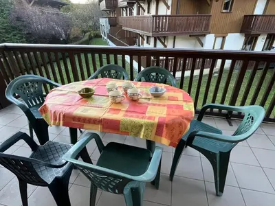 a table with bowls and mugs on it on a balcony at Appart spacieux 6 pers Samoëns avec animaux admis - FR-1-629-151 in Samoëns