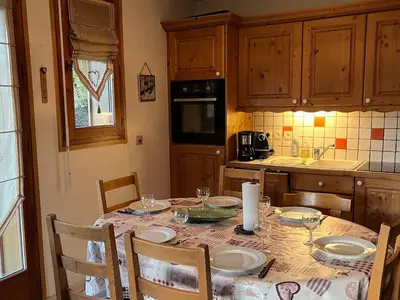 a kitchen with a table with plates and glasses on it at Appart spacieux 6 pers Samoëns avec animaux admis - FR-1-629-151 in Samoëns
