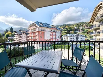 a table and chairs on a balcony with buildings at Appartement cosy à Saint-Gervais, proche télécabine, parking inclus - FR-1-663-57 in Saint-Gervais-les-Bains