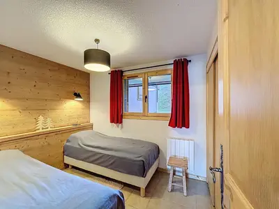 a bedroom with two beds and a window with red curtains at Appartement cosy avec balcon près du centre de Combloux - FR-1-560-170 in Combloux