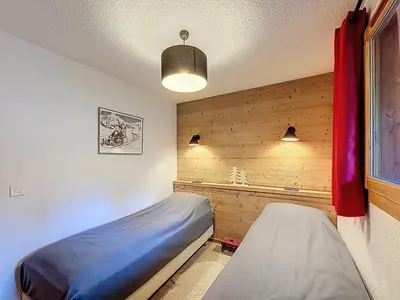 a bedroom with a bed in a room with wooden walls at Appartement cosy avec balcon près du centre de Combloux - FR-1-560-170 in Combloux