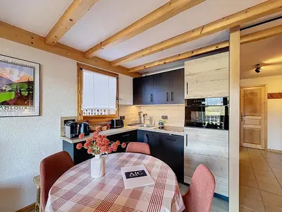 a kitchen with a table and chairs in a kitchen at Appartement cosy avec balcon près du centre de Combloux - FR-1-560-170 in Combloux