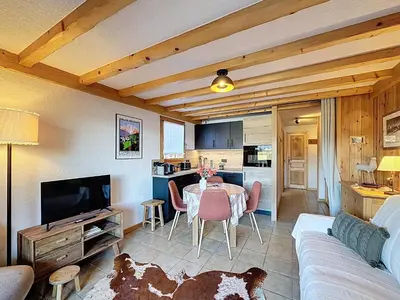 a living room with a table and a kitchen at Appartement cosy avec balcon près du centre de Combloux - FR-1-560-170 in Combloux