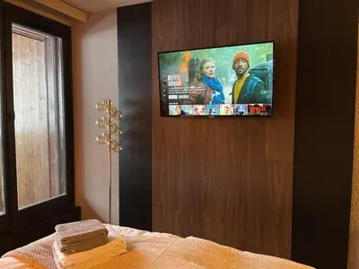 a bedroom with a flat screen tv on a wall at Central Chamonix, Charming Studio & Balcony in Chamonix-Mont-Blanc
