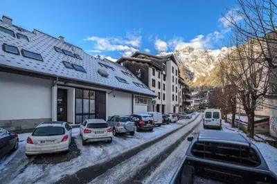 a snowy street with cars parked in a parking lot at Central Chamonix, Charming Studio & Balcony in Chamonix-Mont-Blanc
