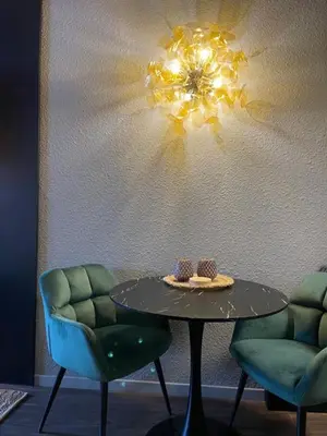 a table with two chairs and a chandelier on a wall at Central Chamonix, Charming Studio & Balcony in Chamonix-Mont-Blanc